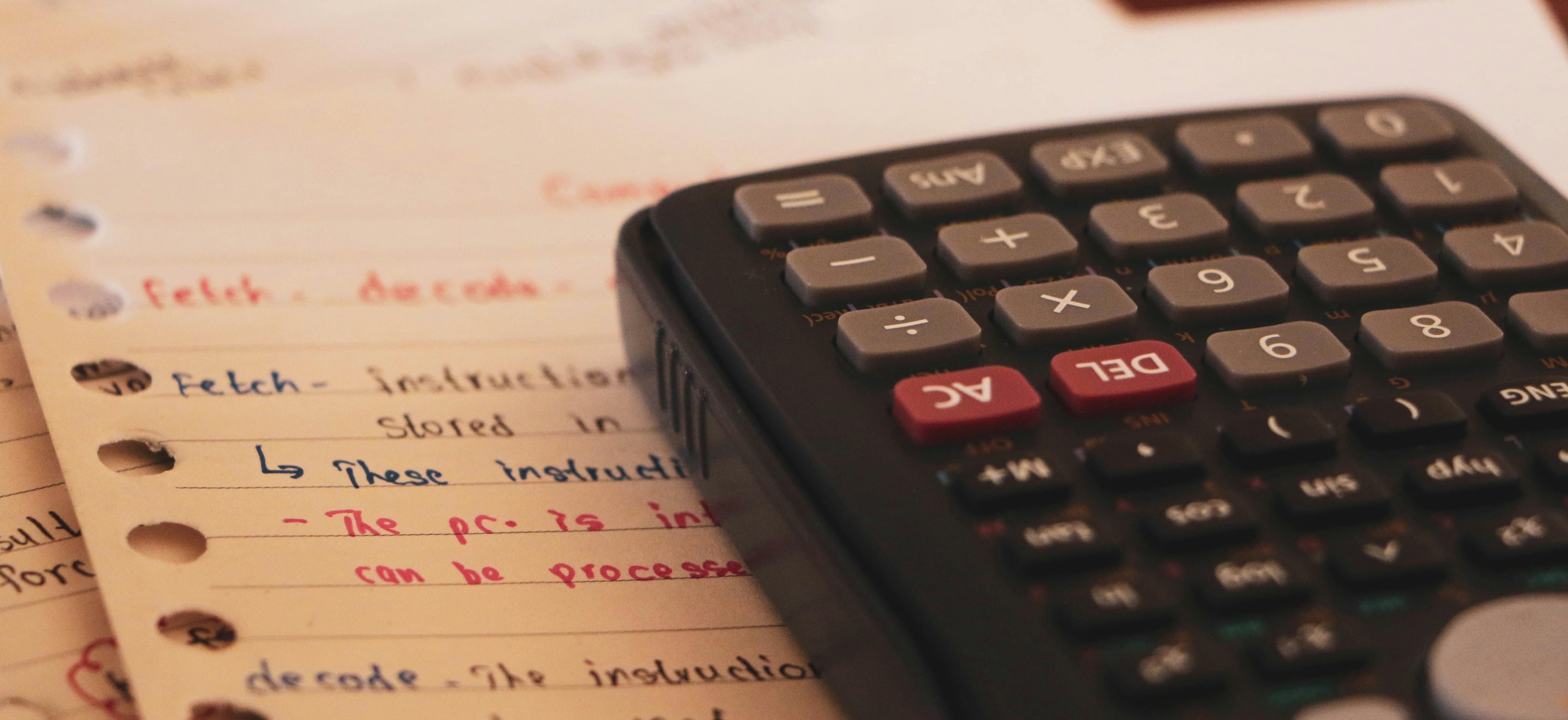 A scientific calculator with paper work